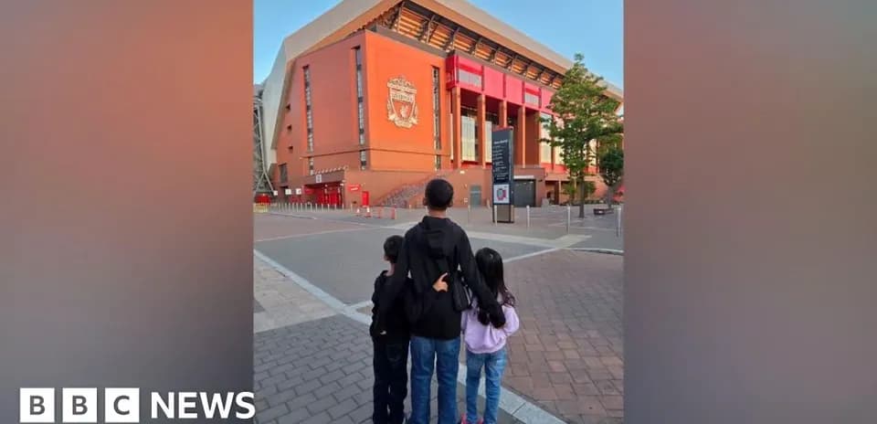 Three children in front of Anfield stadium