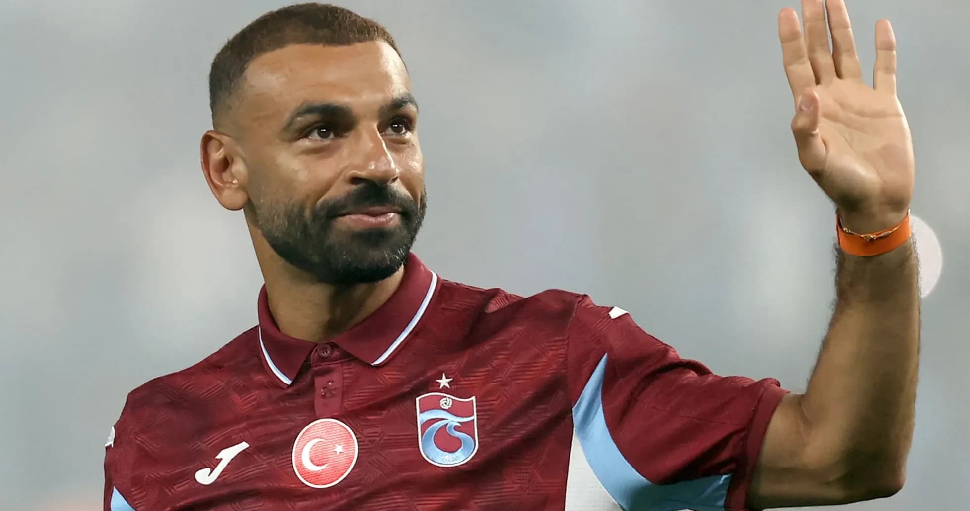 Futbolchi qo'lini ko'tarib salom bermoqda