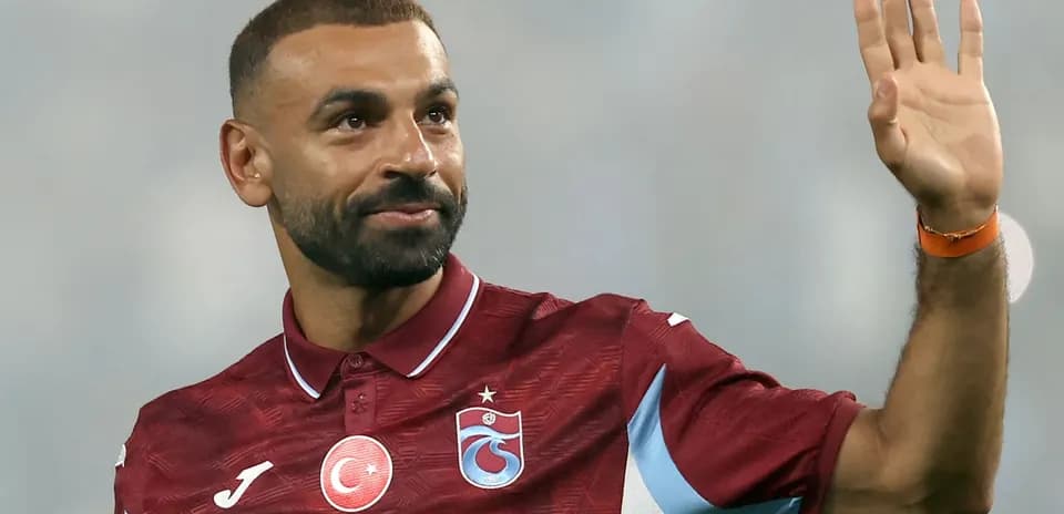 Futbolchi qo'lini ko'tarib salom bermoqda