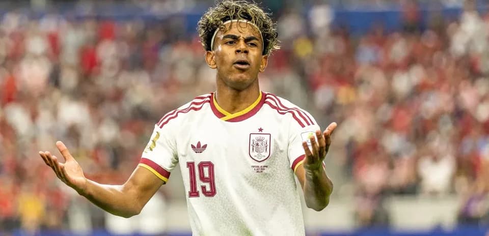 Futbolchi maydonda harakat qilib, qo'llarini ochmoqda