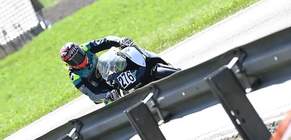Rider leaning into a turn on motorcycle at track