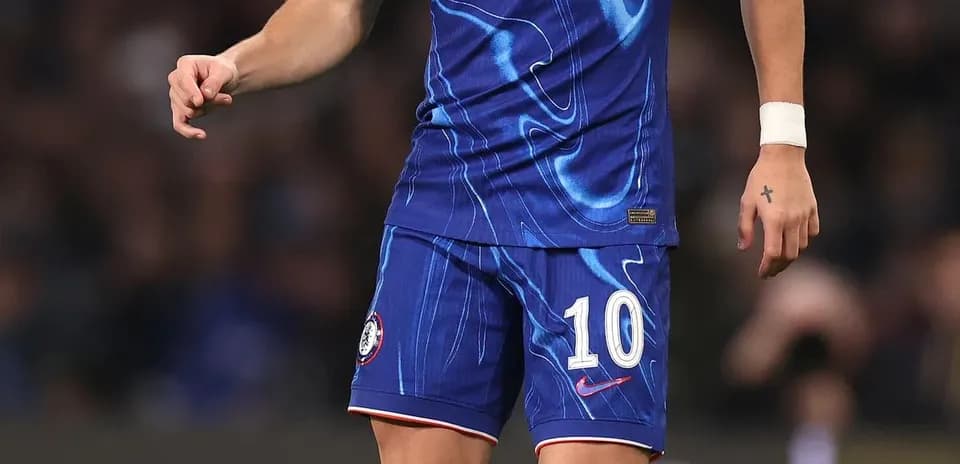 Futbolchi Chelsea formasida to'p bilan maydonda