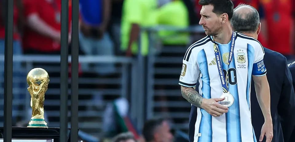 Lionel Messi walking past World Cup trophy after match
