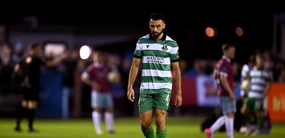 Futbolchi maydonda pastga qarab yurmoqda