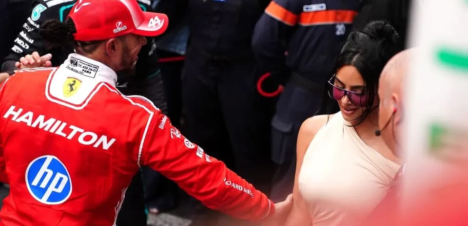 Formula 1 driver interacting with a woman in crowd