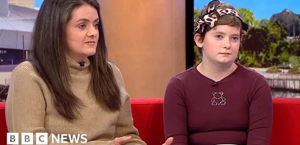 Two women sitting on a red sofa during interview