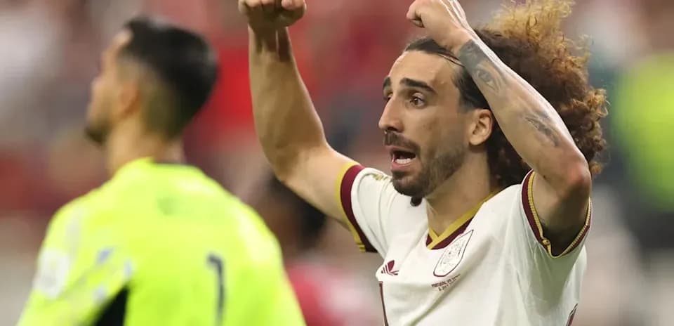Futbolchi maydonda qo'llarini ko'tarib nishonlamoqda