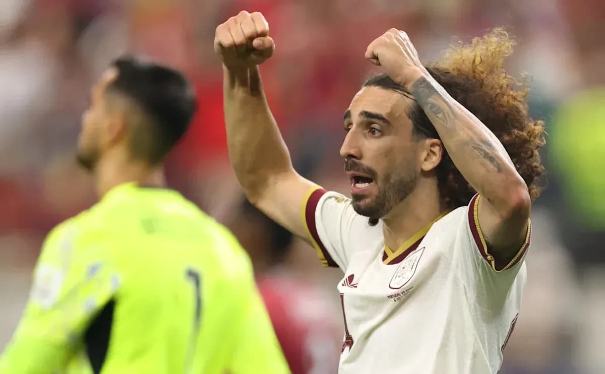 Futbolchi maydonda qo'llarini ko'tarib nishonlamoqda