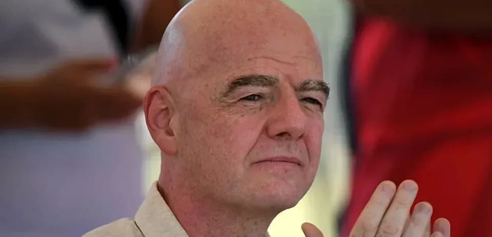 FIFA president attending an event, hands clasped