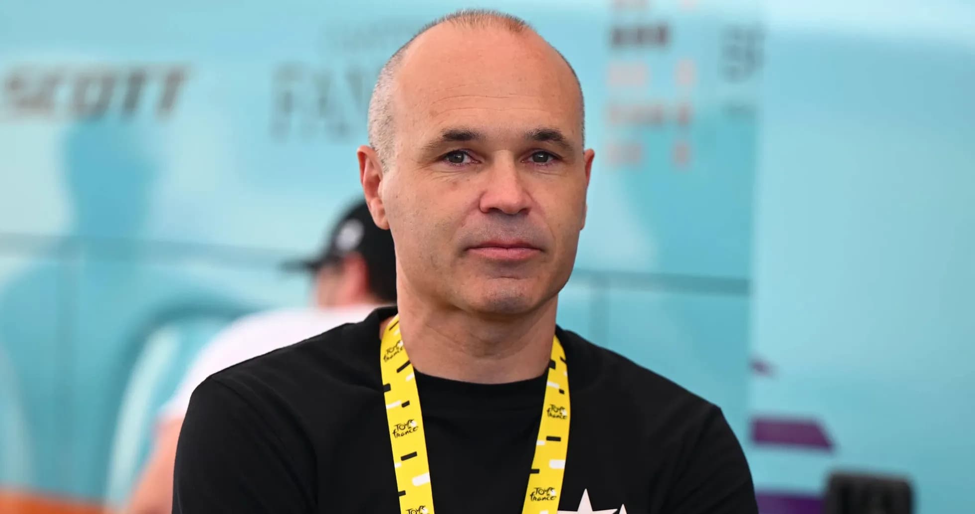 Man with lanyard at cycling event backdrop