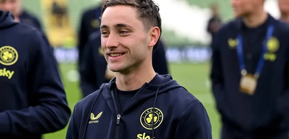 Futbolchi maydonda jamoa a'zolari bilan suhbatalashmoqda