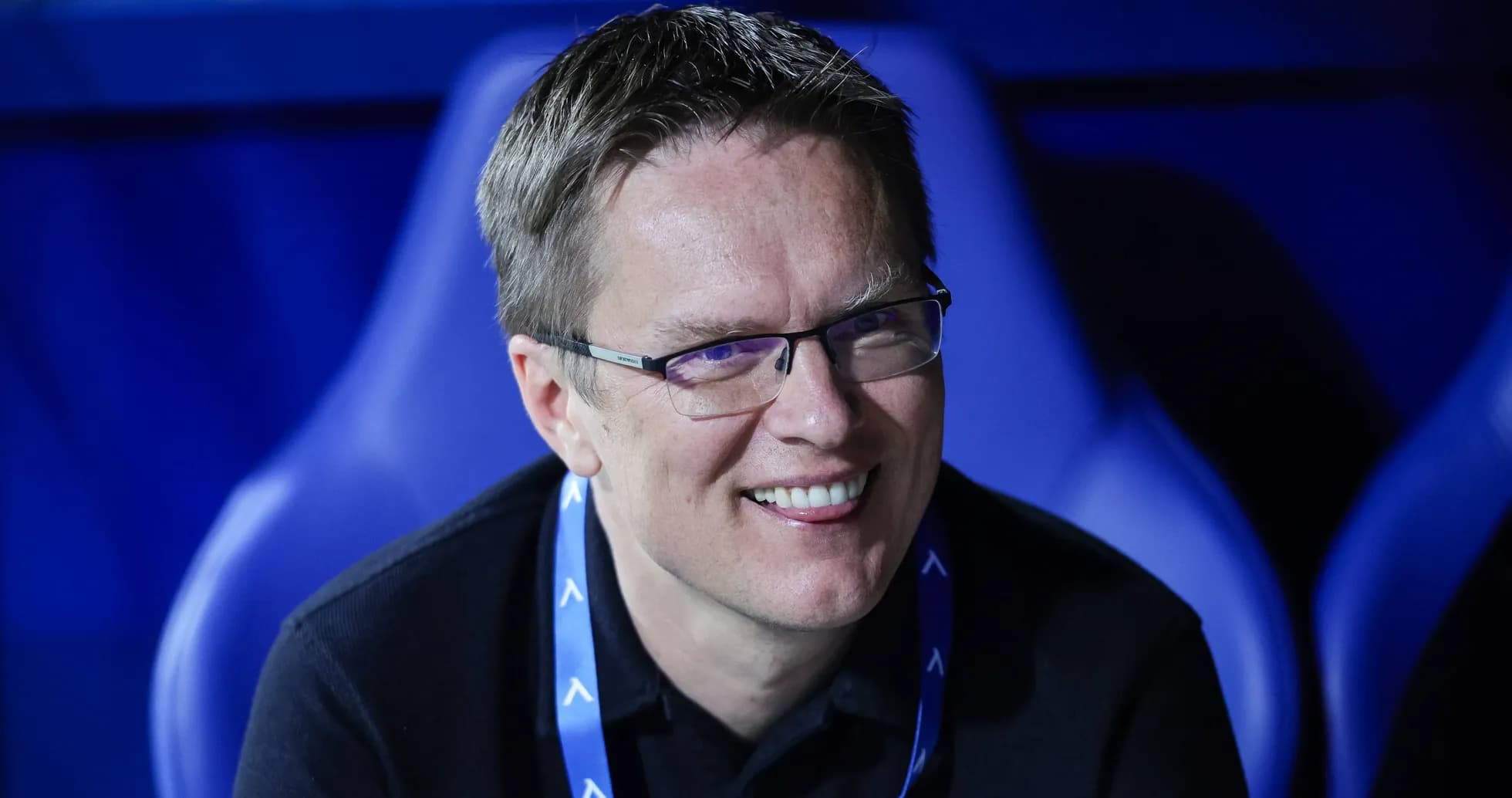 Smiling man seated in sports venue