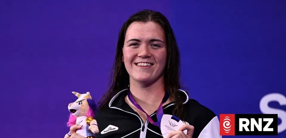 Athlete holding medal and plush toy at event