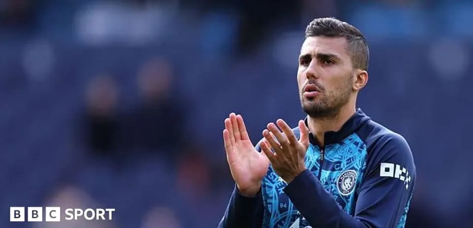Futbolchi maydonda qo'llarini ko'tarib turgan