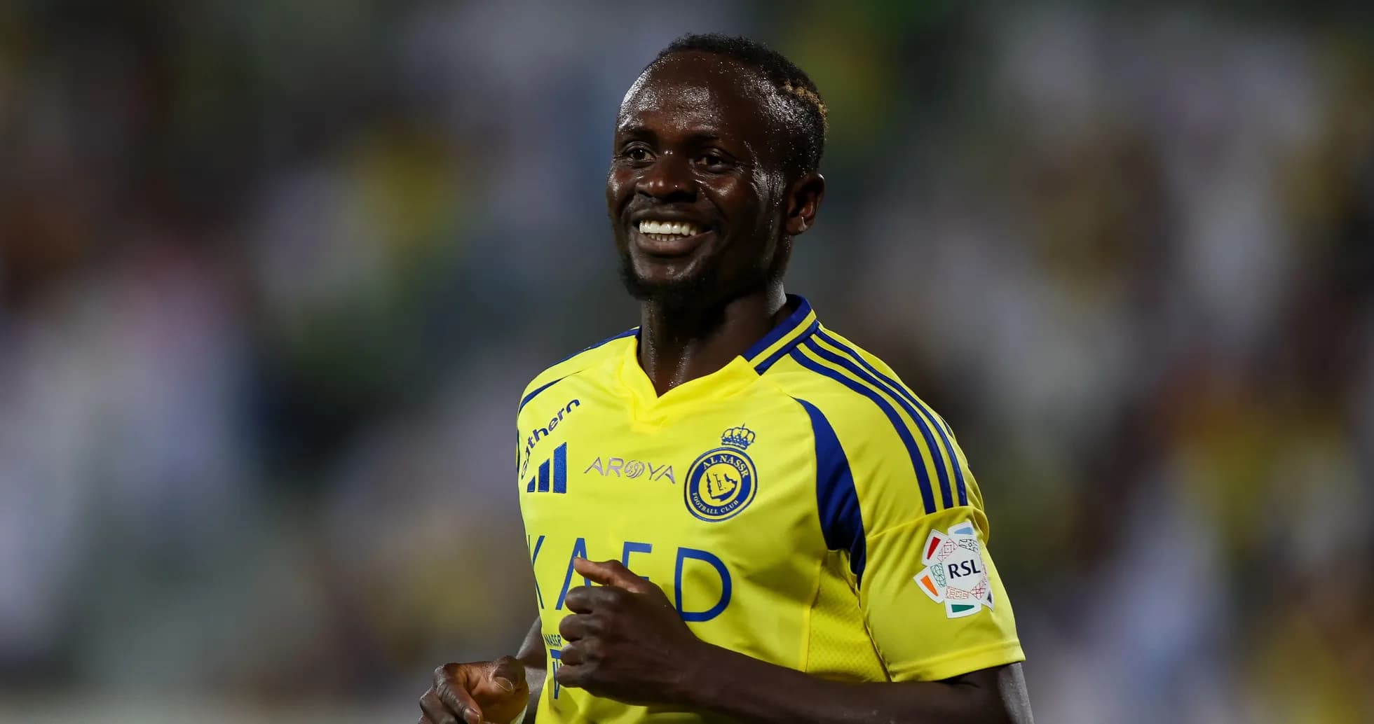 Futbolchi maydonda quvonch bilan yugurmoqda