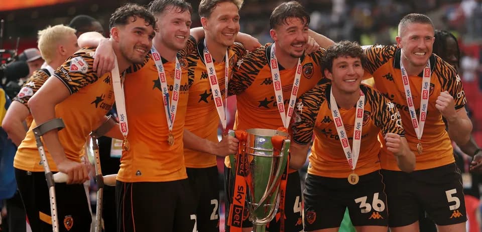 Hull City players celebrating with trophy and medals