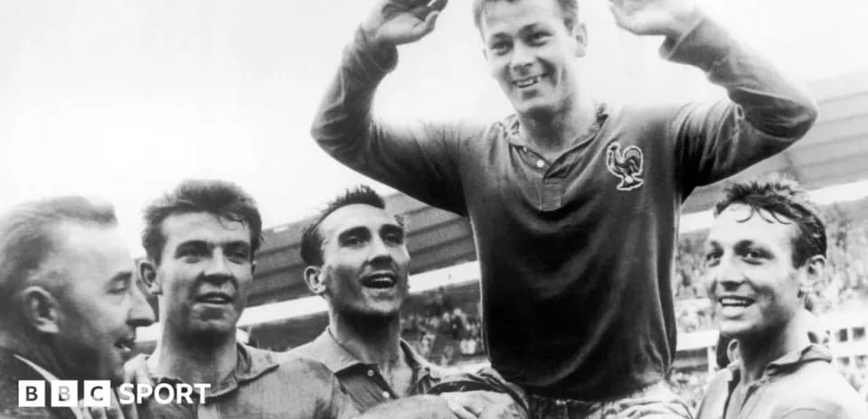 Football players celebrating victory, one lifted in air