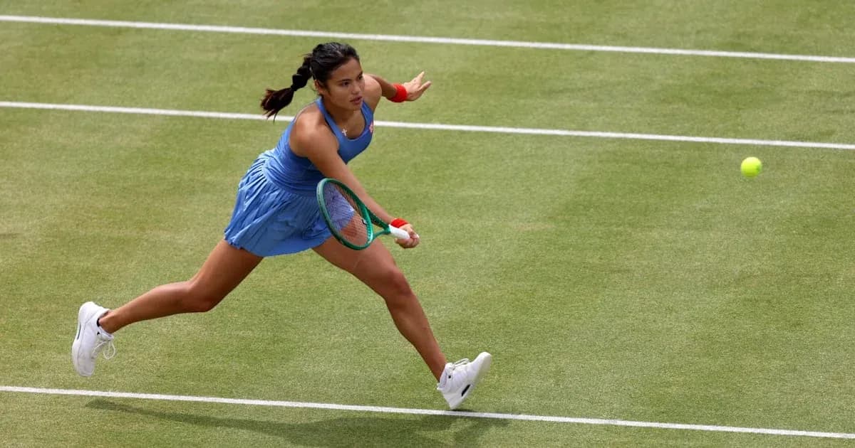 Tennis player reaching for a ball on grass court