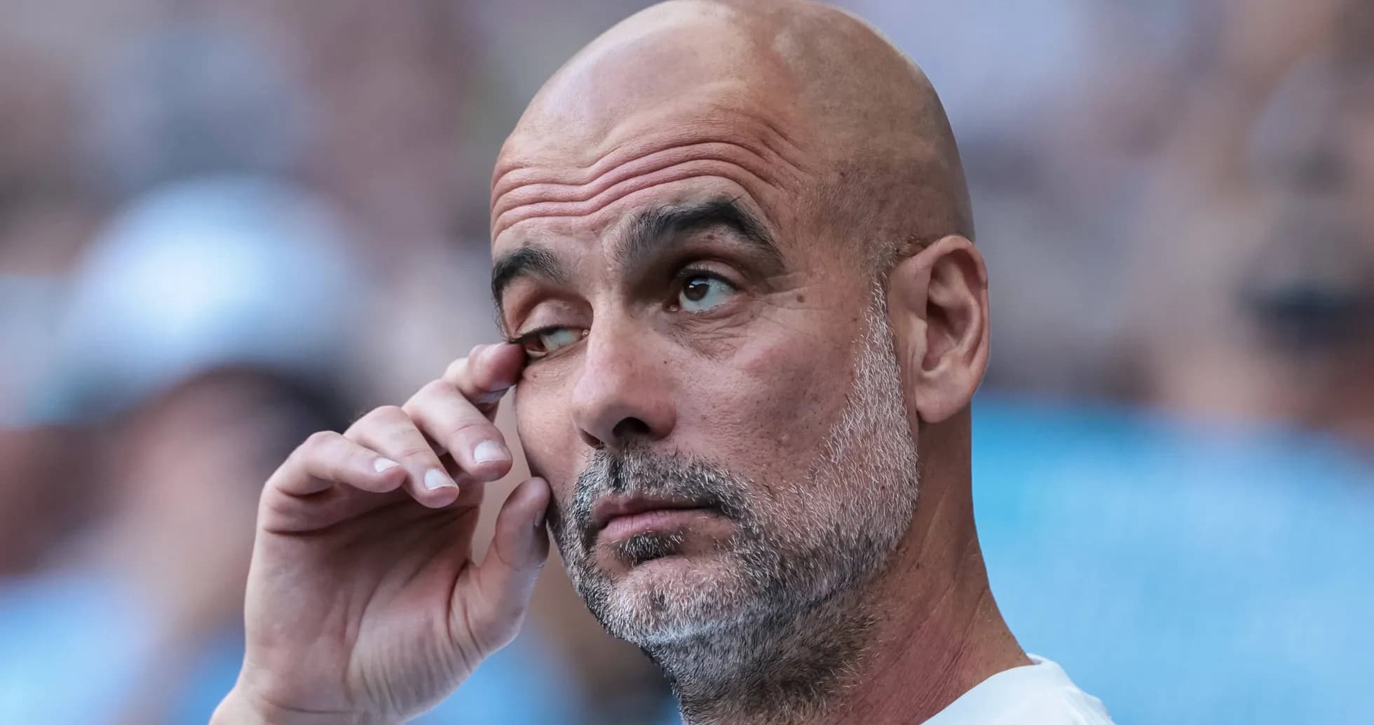 Football manager touching his eye during match