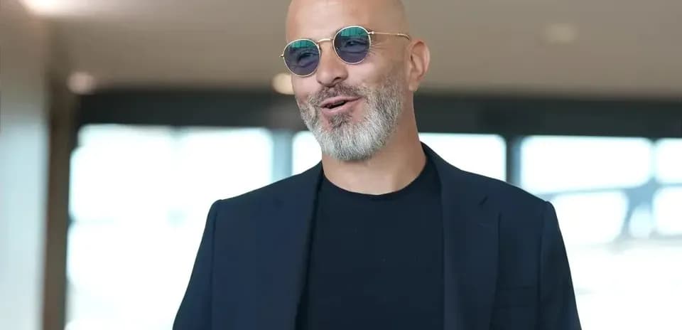 Man in sunglasses smiling in modern interior
