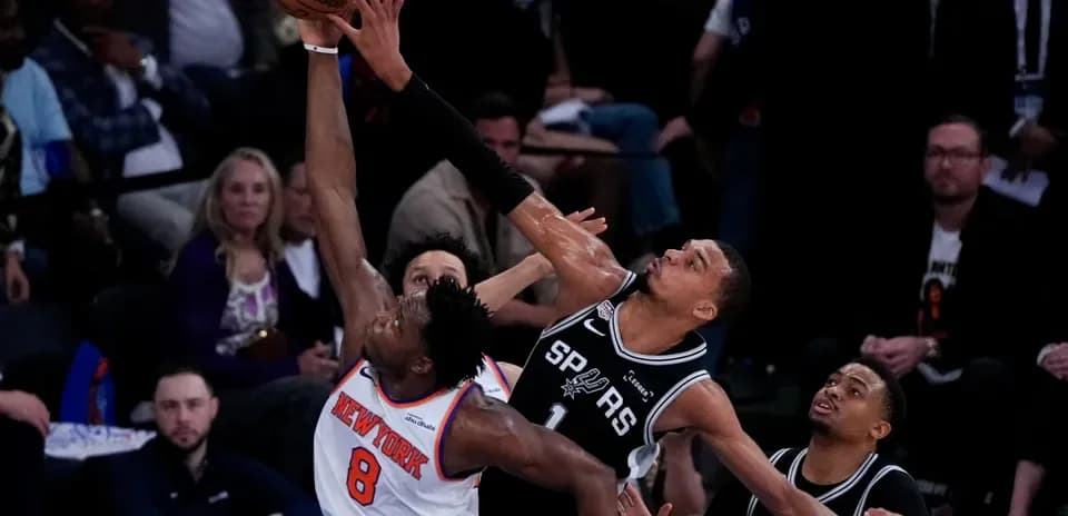 New York player attempting a shot against Spurs defense
