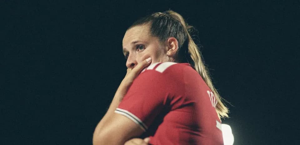Futbolchi o'yin davomida qo'lida yuzini ushlab turmoqda