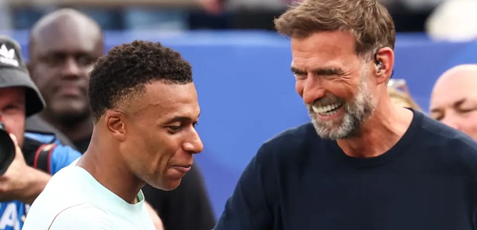Kylian Mbappé and coach smiling during interaction