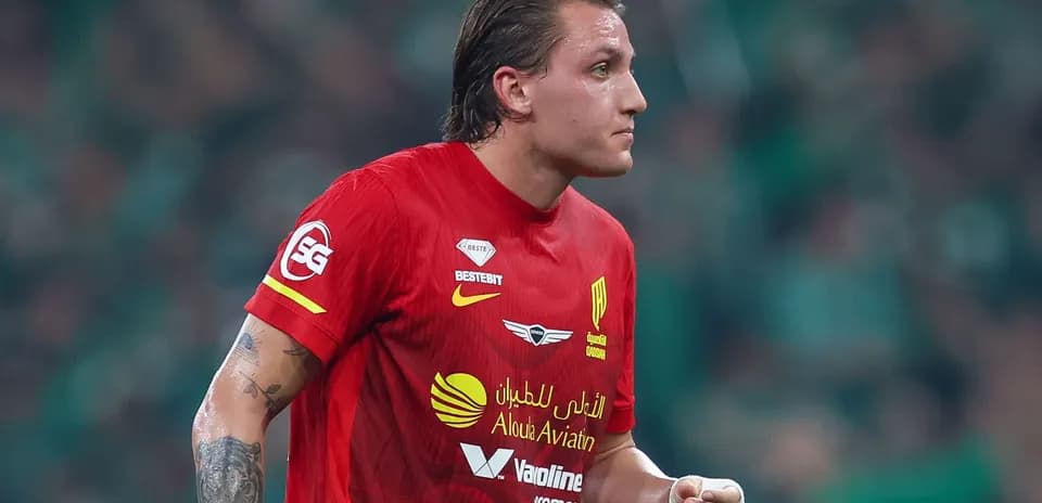Futbolchi qizil formada maydonda harakatda