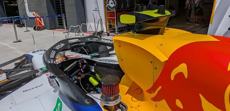 Formula 1 car in the pit area with team members