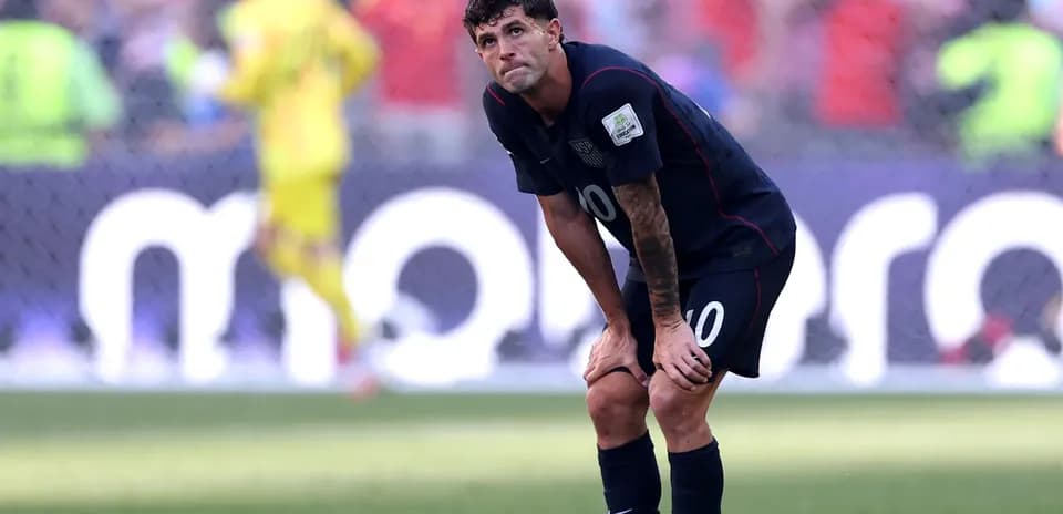 Futbolchi maydonda egilib, o'ylab turibdi