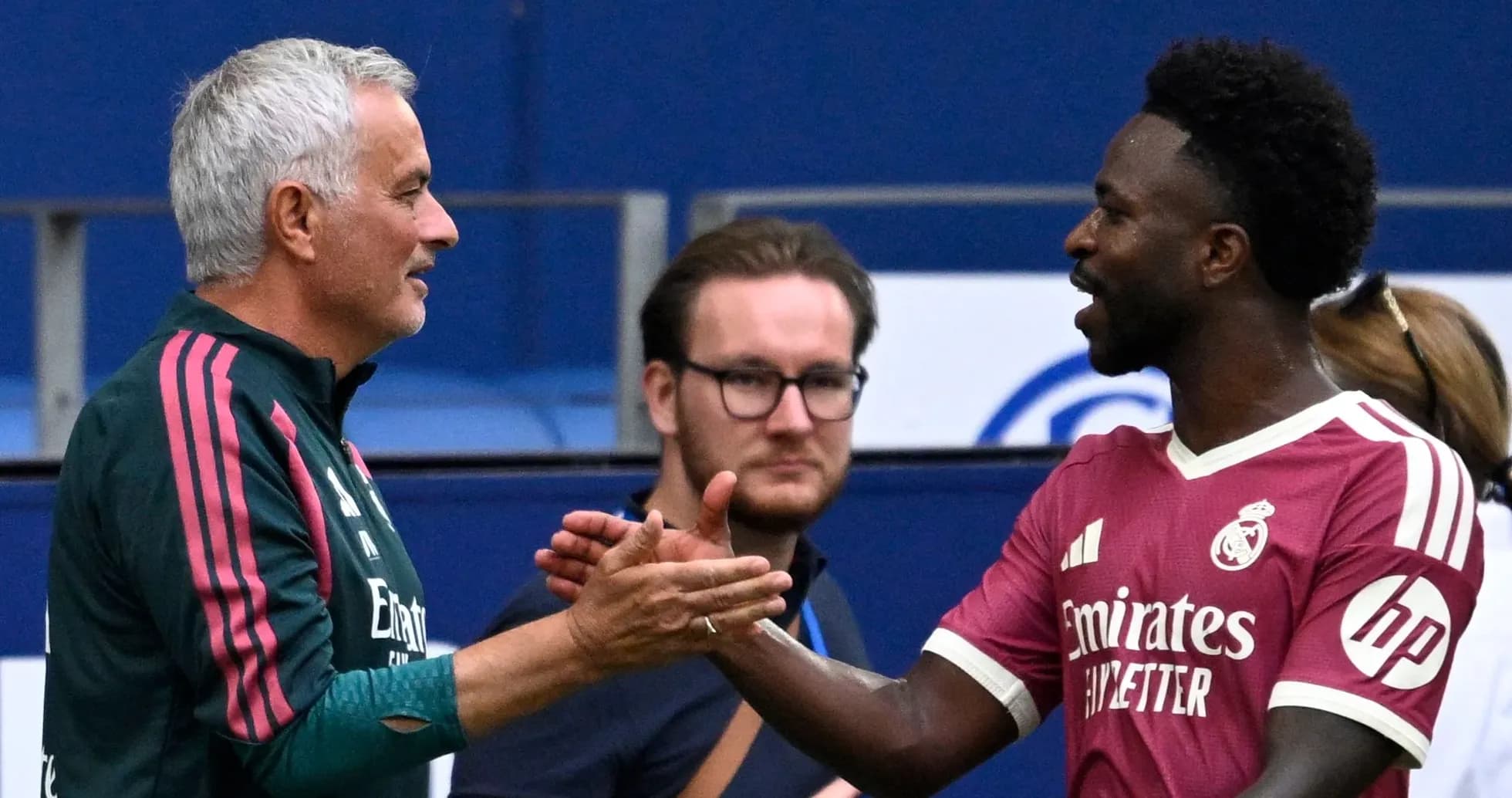 Trener va futbolchi bir-biriga qo'l berishmoqda