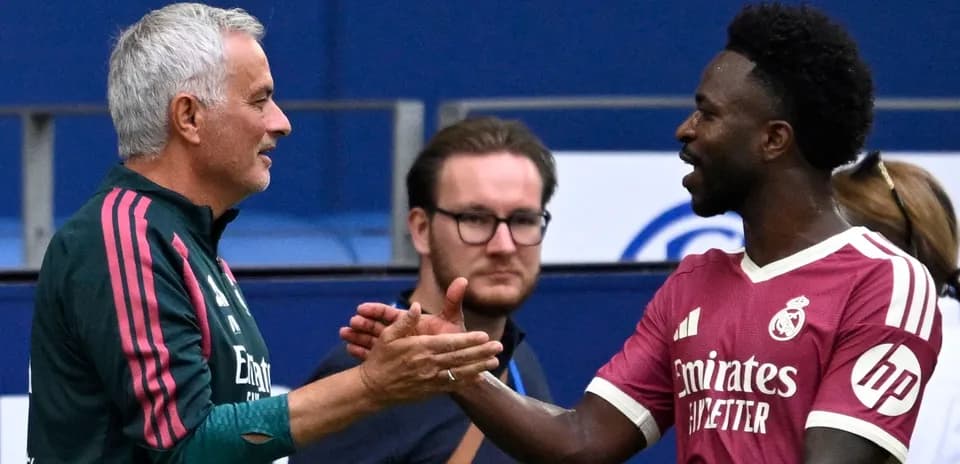 Trener va futbolchi bir-biriga qo'l berishmoqda