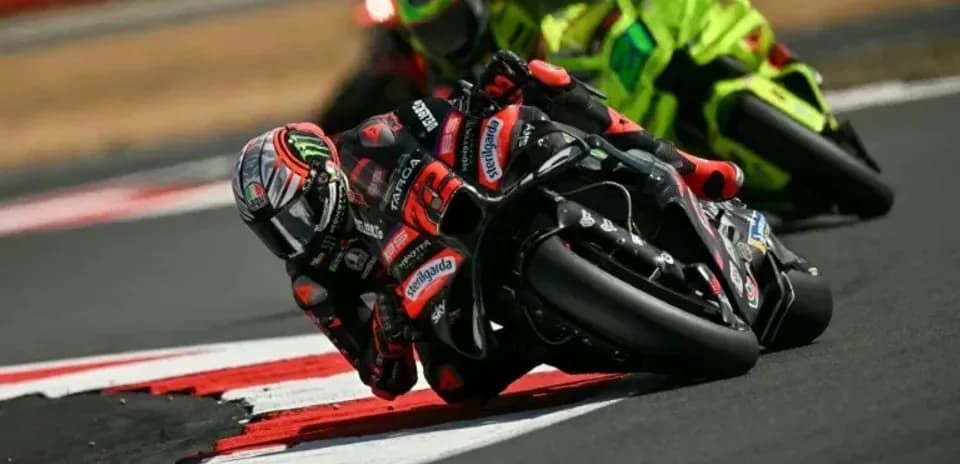 Motocycle racers leaning into a curve on track