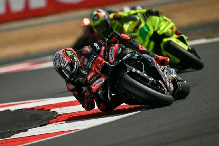Motocycle racers leaning into a curve on track