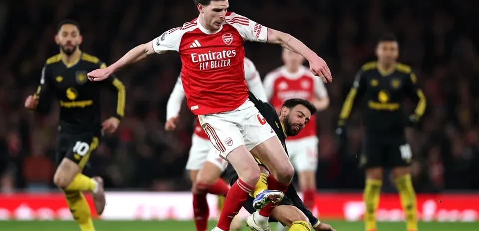Arsenal player tackling opponent during match action