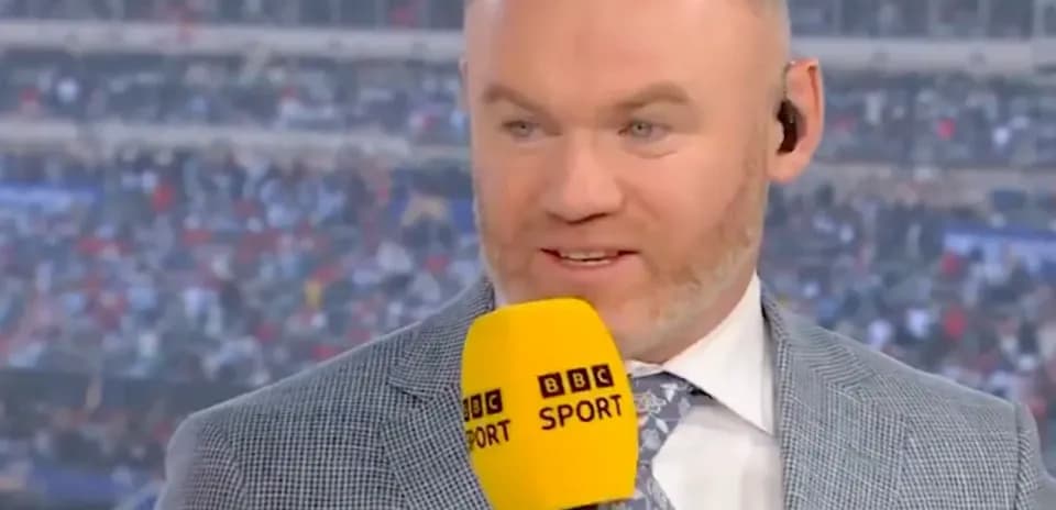 Analyst speaking on set with microphone at stadium