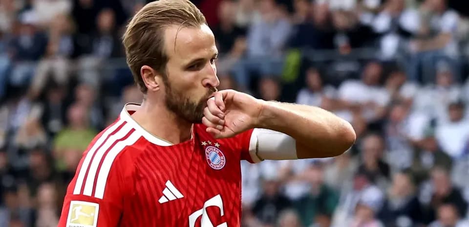 Futbolchi Bayern Munich formasida, qo'lini o'pidan boshqaradi