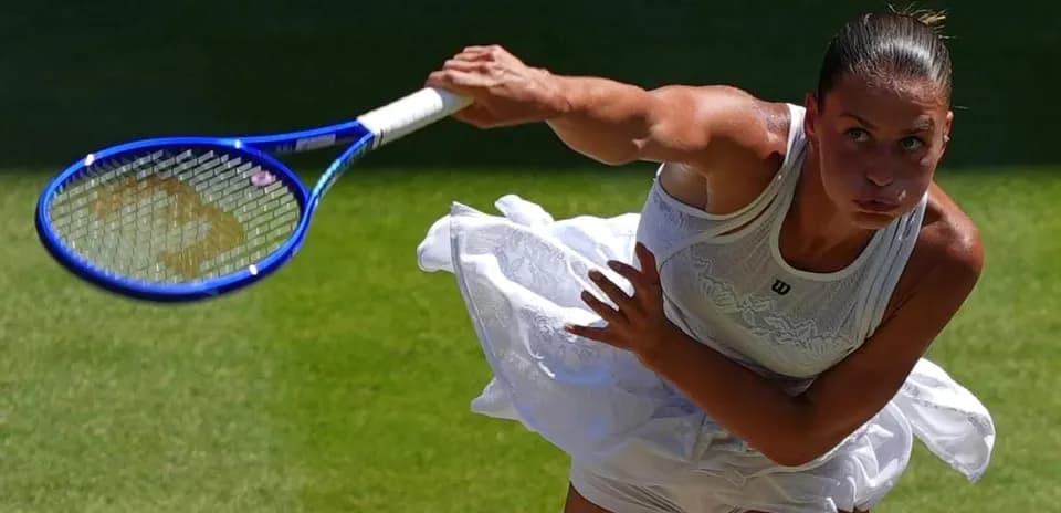 Tennis player serving during a match on grass court