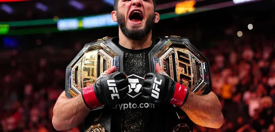 Fighter celebrating with two UFC championship belts
