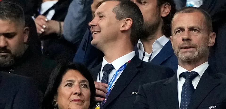 Officials watching a football match in the stands