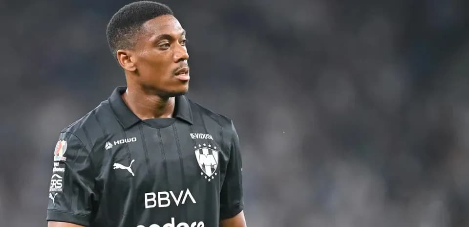 Futbolchi qora formada maydonni kuzatmoqda