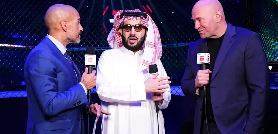 Three men speaking with microphones near UFC octagon