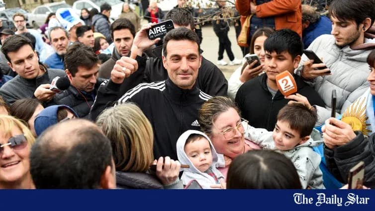 Odamlar bilan birga turgan erkak, qo'lini ko'tarib turibdi