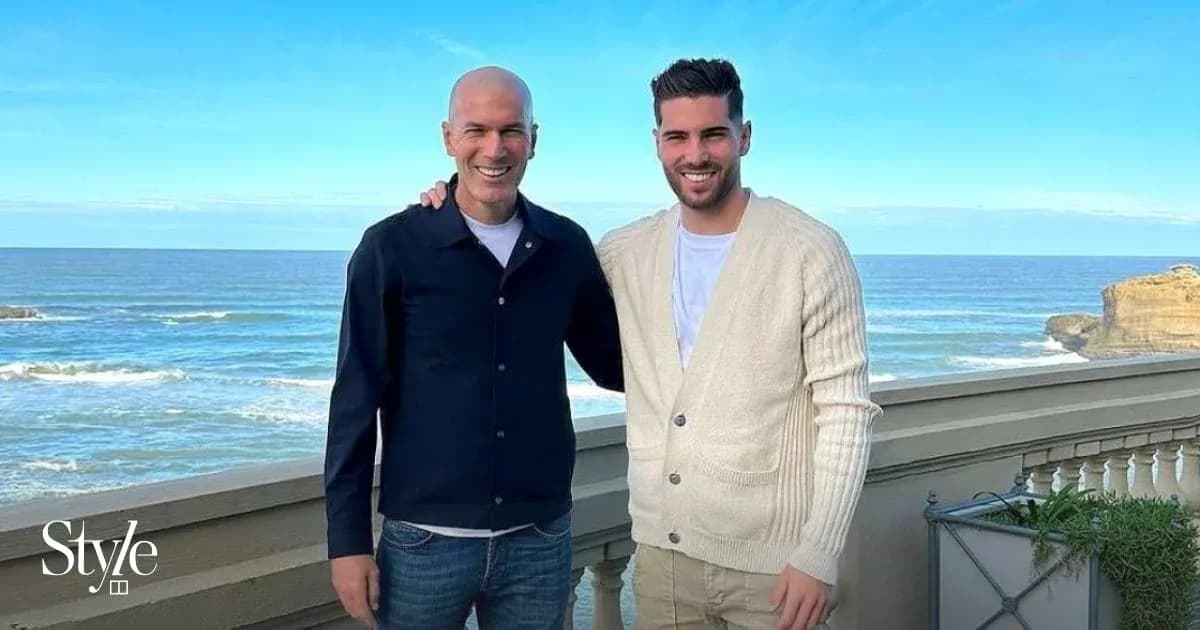 Two men posing by the ocean with blue sky