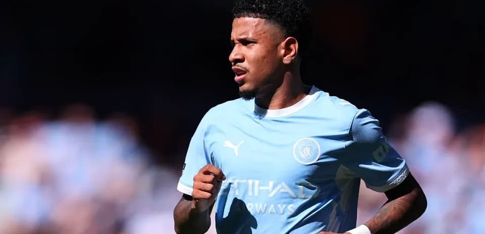 Futbolchi Manchester City formasida maydonda yugurmoqda