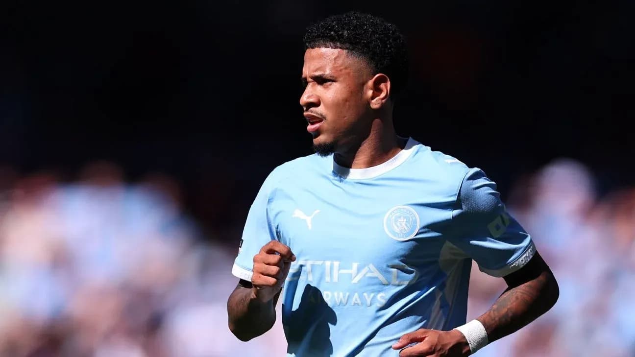 Futbolchi Manchester City formasida maydonda yugurmoqda