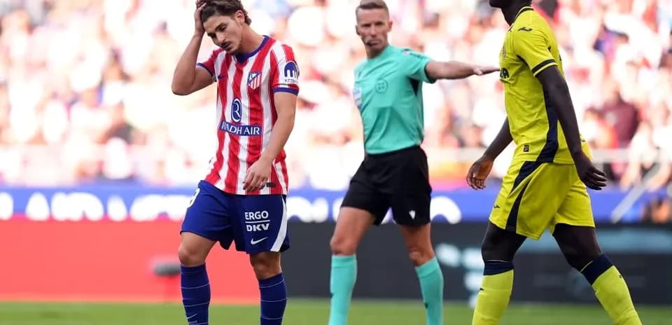 Atlético Madrid player reacting during match with referee