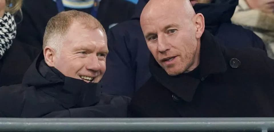 Two men talking in the stands at a match