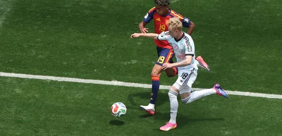 Ikkita futbolchi to'pni nazorat qilishga harakat qilmoqda