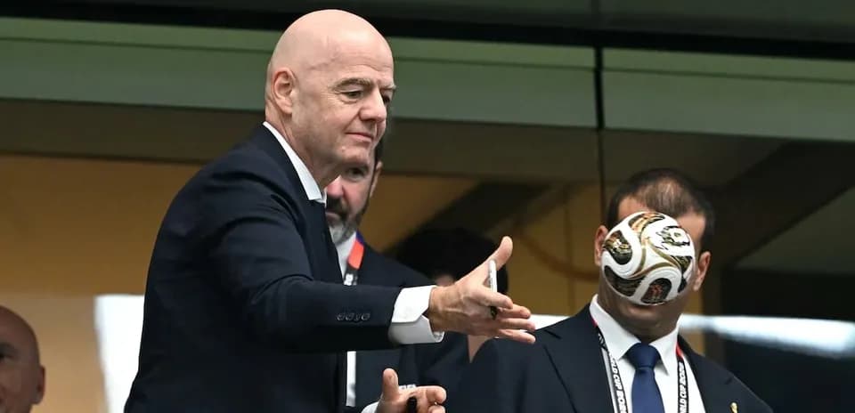 FIFA president tossing a soccer ball in a box